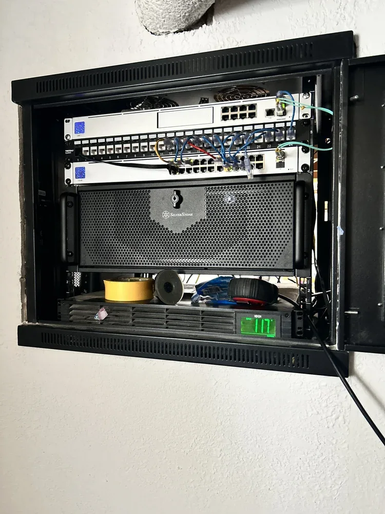Wall-mounted network cabinet with two switches, a patch panel and battery backup